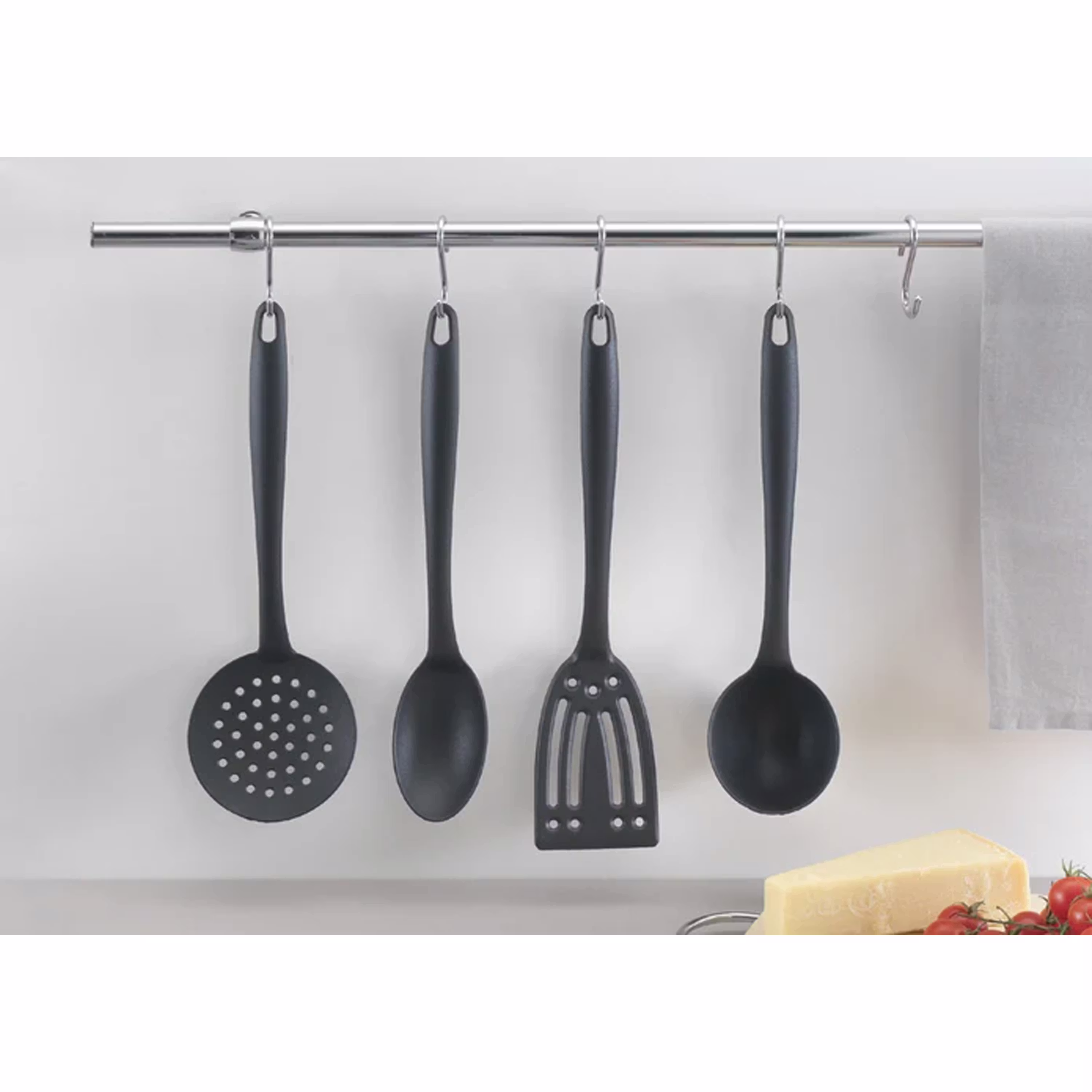 Set of black kitchen utensils hanging on a wall‑mounted metal rod.